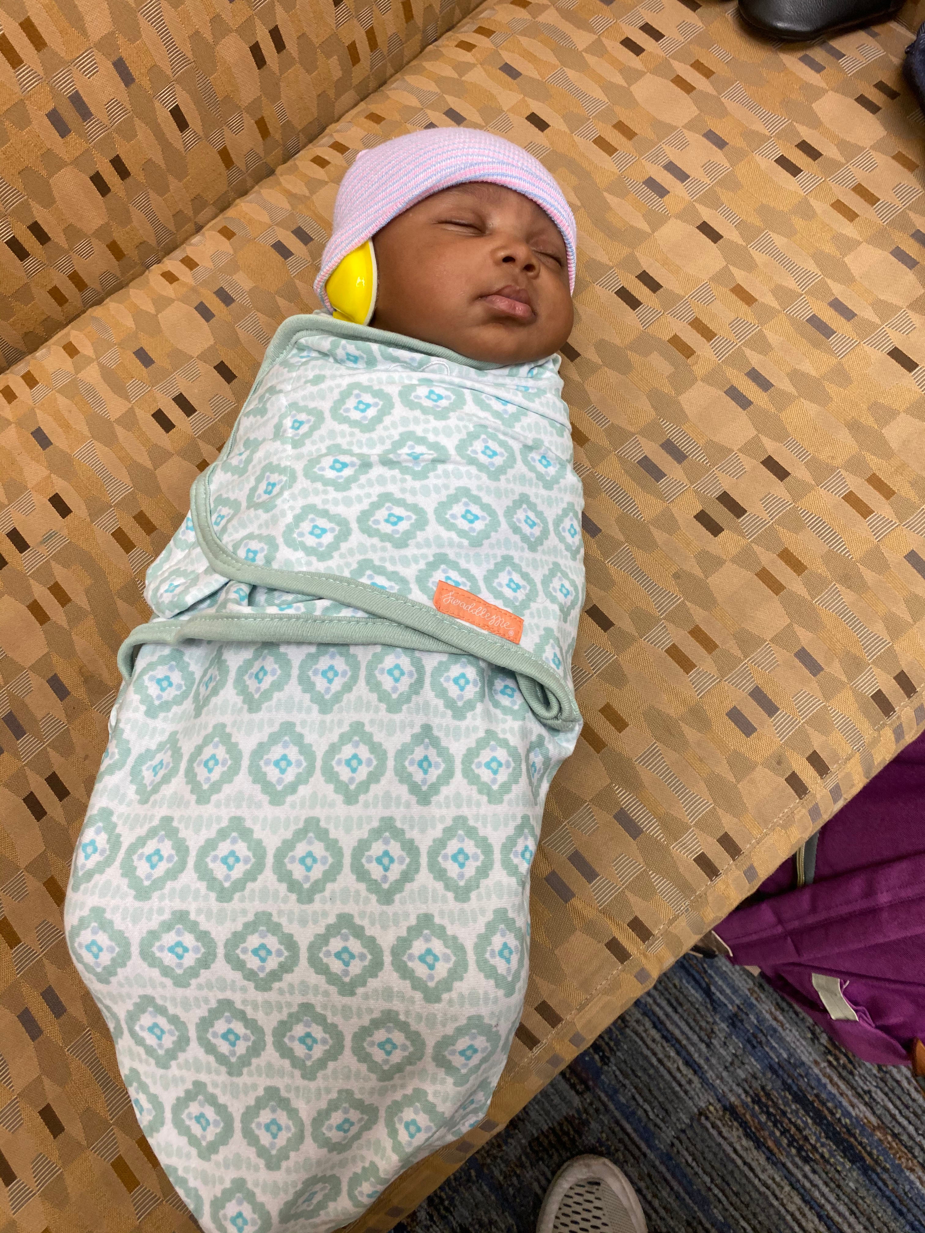 Photo caption: A baby, swaddled and wearing ear protectors to help them stay asleep naturally, is prepared for an MRI scan as part of the HEALthy Brain and Child Development Study.